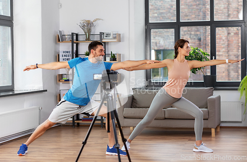 Image of couple recording home yoga class video