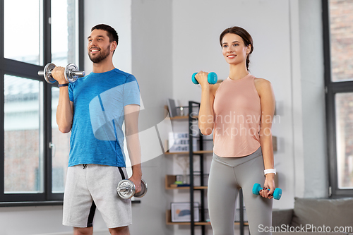 Image of happy couple exercising at home