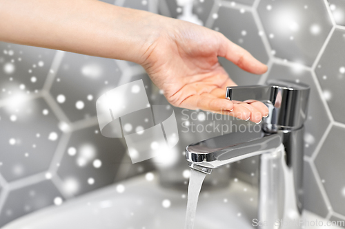 Image of close up of woman's hand opening water tap