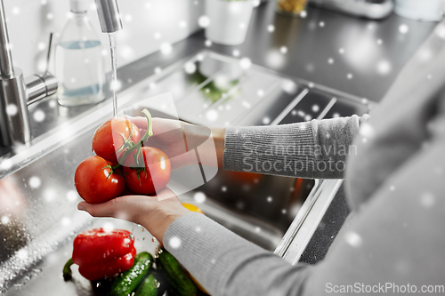 Image of close up of woman washing vegetables in kitchen