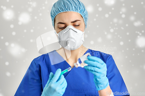 Image of doctor in face mask with syringe and medicine