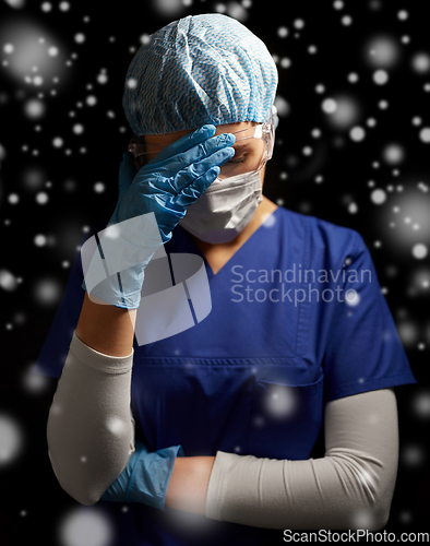 Image of sad doctor or nurse in goggles and face mask