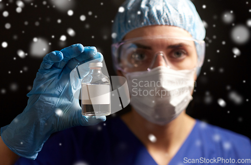 Image of close up of doctor's hand with bottle of medicine