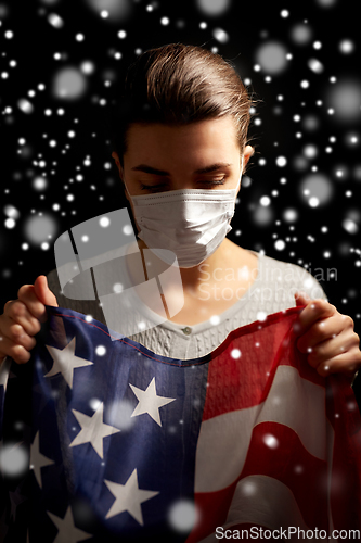 Image of sick woman in face mask holding flag of america