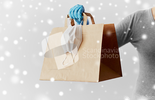 Image of woman with shopping bag, face mask and gloves