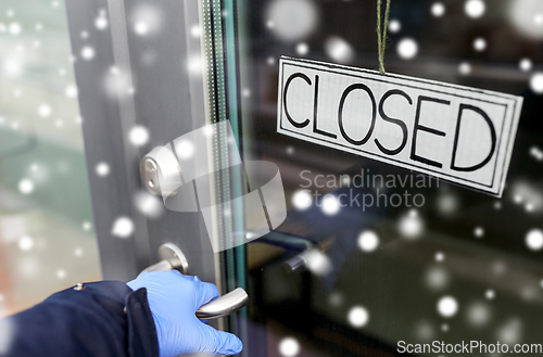 Image of hand in medical glove holding to closed door