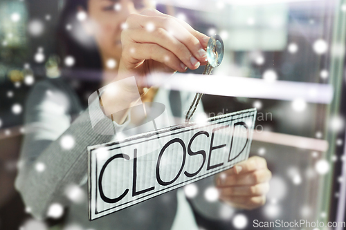 Image of woman hanging banner with closed word on door