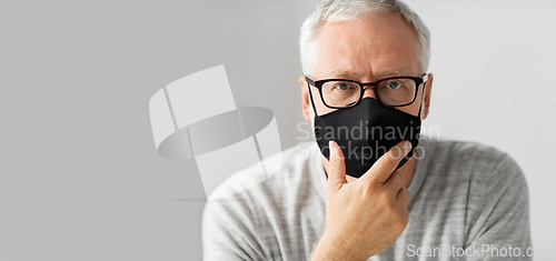 Image of close up of senior man in glasses and black mask