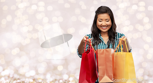 Image of happy asian woman with shopping bags