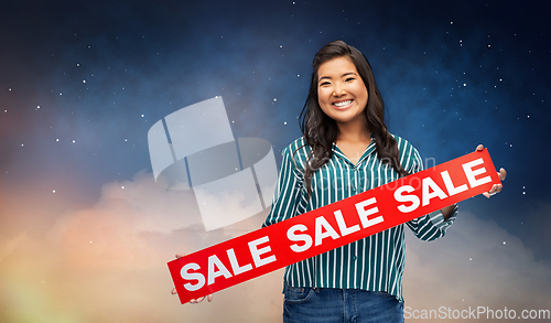 Image of happy smiling young asian woman with sale banner