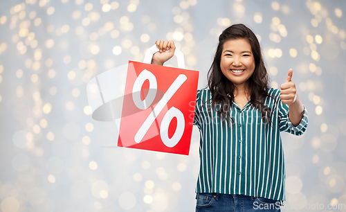 Image of asian woman with percentage sign on shopping bags