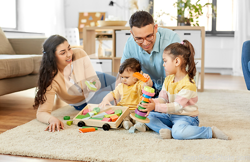 Image of happy family palying with wooden toys at home