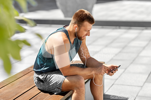 Image of young athlete man with earphones and smartphone