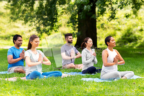 Image of group of happy people doing yoga at summer park