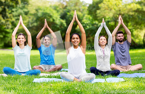 Image of group of happy people doing yoga at summer park