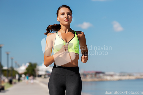 Image of young woman running at seaside