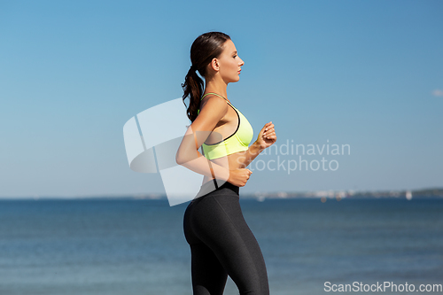 Image of young woman running at seaside