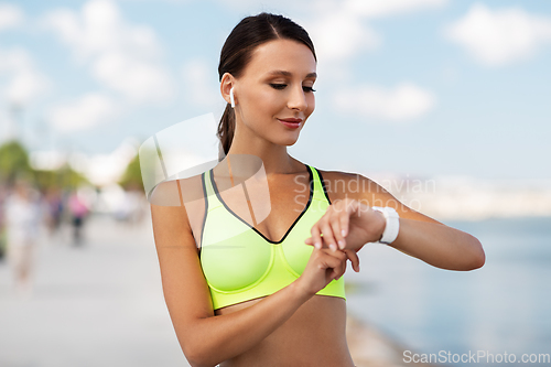 Image of woman with earphones and smart watch doing sports