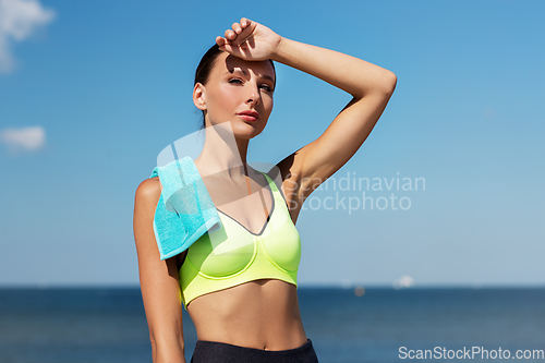 Image of tired woman with towel after sports outdoors