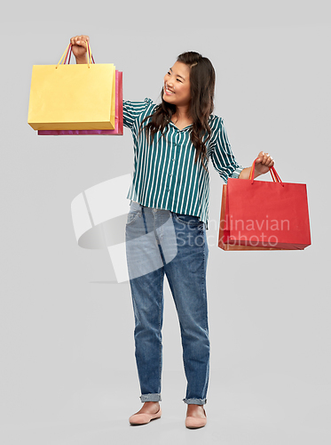 Image of happy asian woman with shopping bags