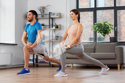 Image of couple exercising and doing lunge at home