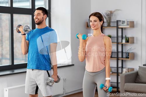 Image of happy couple exercising at home