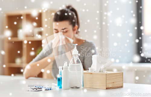 Image of medicines and sick woman blowing nose to wipe