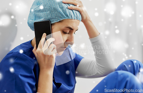 Image of sad doctor or nurse calling on smartphone