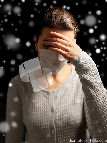 Image of sick young woman in protective medical face mask