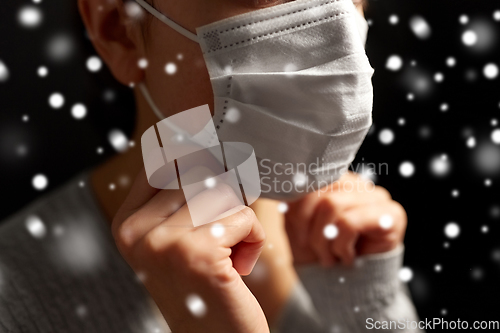 Image of sick woman adjusting protective medical face mask