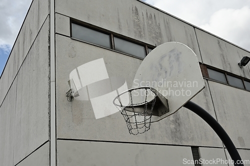 Image of an anti-vandal basketball hoop with iron chains against a gloomy
