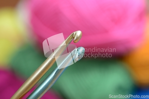 Image of two crochet hooks on a colorful background