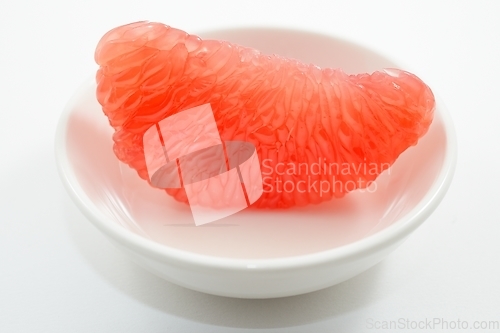 Image of juicy red grapefruit slice on white