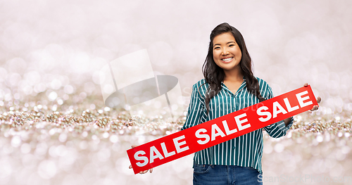 Image of happy smiling young asian woman with sale banner