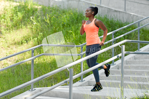 Image of young african american woman running downstairs