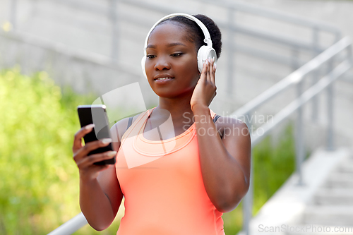 Image of african american woman with headphones and phone