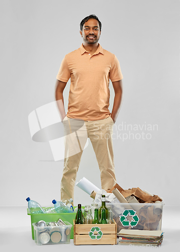 Image of smiling man sorting paper, glass and plastic waste