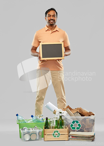 Image of smiling man sorting paper, glass and plastic waste