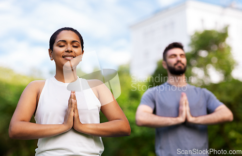 Image of group of people doing yoga at summer park