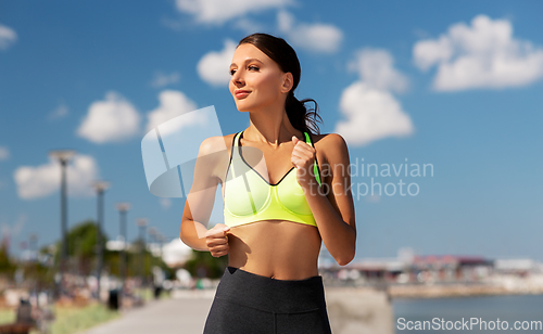 Image of young woman running at seaside