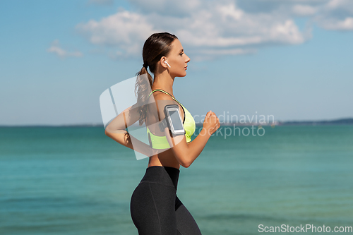 Image of woman with earphones and smartphone running