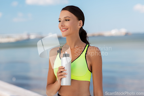 Image of woman drinking water from bottle after sports