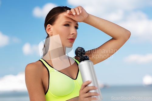 Image of woman drinking water from bottle after sports