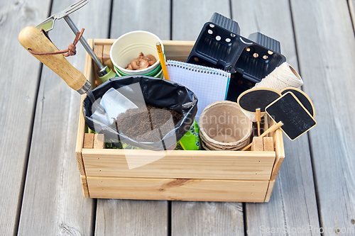 Image of garden tools, soil and pots in wooden box