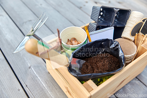 Image of garden tools, soil and pots in wooden box