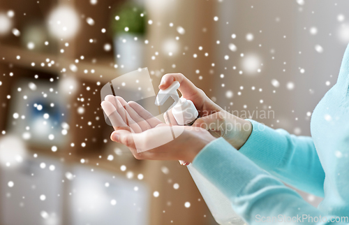 Image of close up of woman applying hand sanitizer