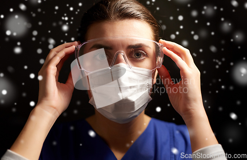 Image of female doctor or nurse in goggles and face mask