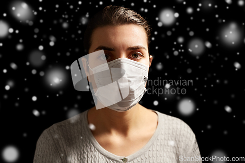 Image of sick young woman in protective medical face mask