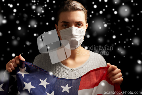 Image of sick woman in face mask holding flag of america