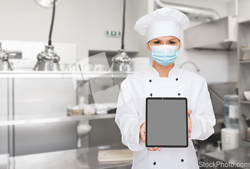 Image of female chef in mask with tablet pc at kitchen